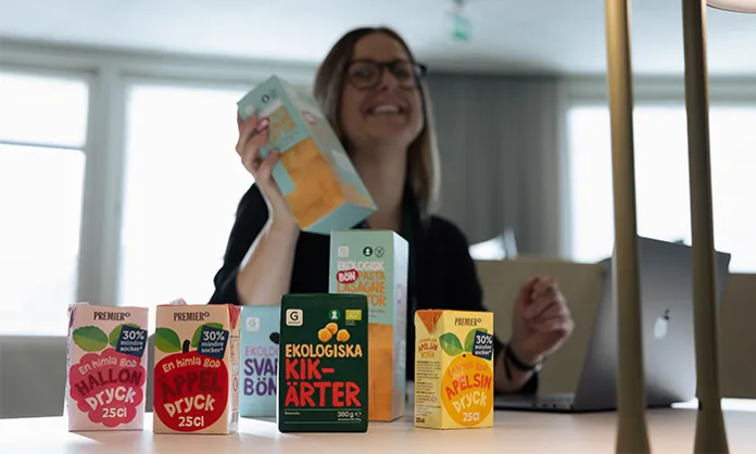 Kvinna ståendes vid ett skrivbord med EMV-produkter uppradade framför sig.