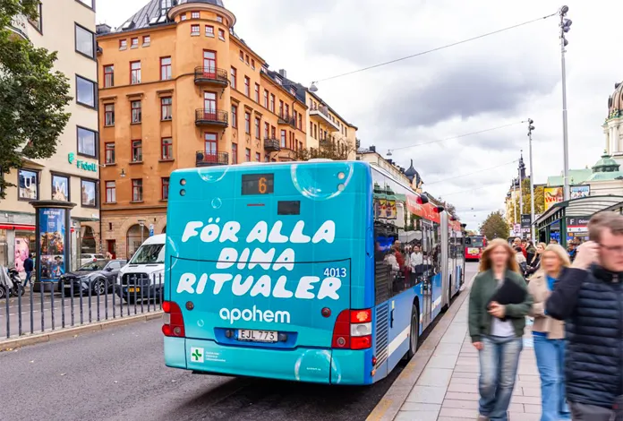 Buss i storstad med reklam från Apohem